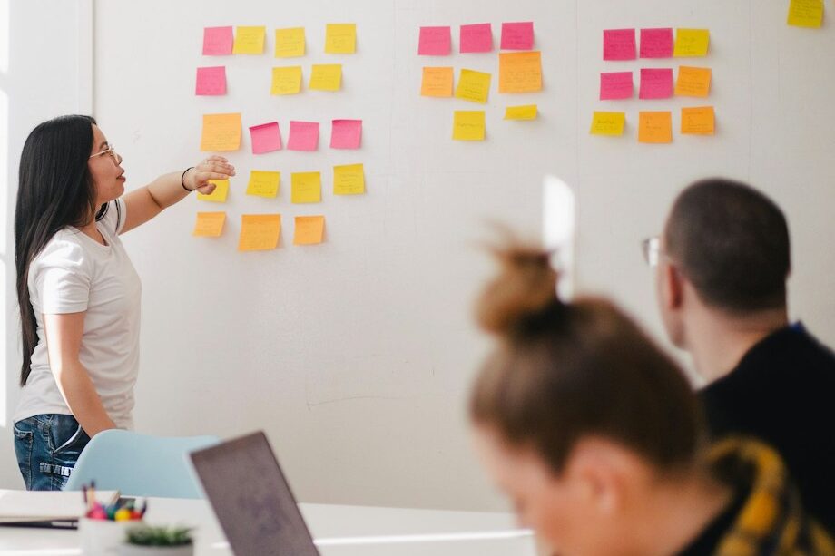 Photo by Jason Goodman woman placing sticky notes on wall
